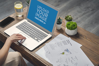 Mockup of a Macbook on a Wooden Desk with Small Plants M15631-r-el2