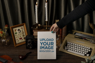Mockup of a Woman Holding a Hard Cover Book Featuring Vintage Objects