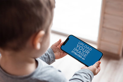 Mockup Featuring a Little Boy Watching a Video on an iPhone m22135-r-el2