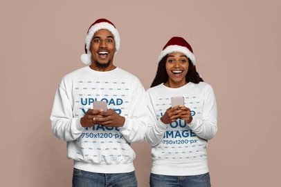 Sweatshirt Mockup Featuring a Smiling Man and Woman With Santa's Hats