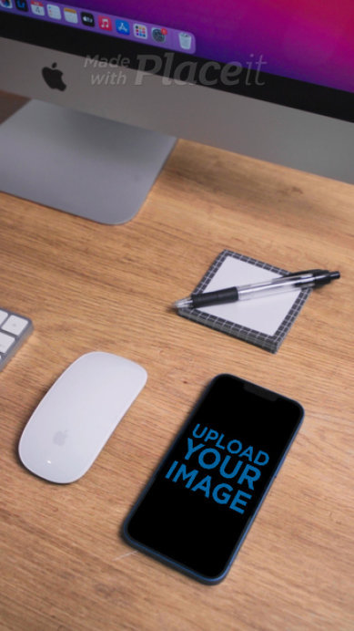 Video of an iPhone 13 Lying on a Wooden Desk with a Mouse and an iMac