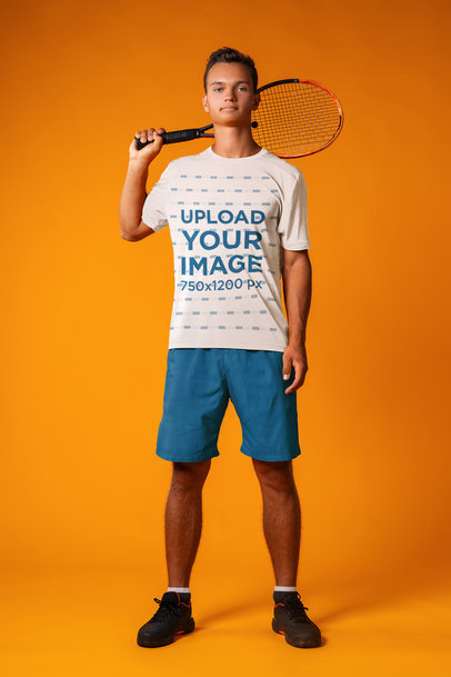 Sports T-Shirt Mockup Featuring a Tennis Player Posing with a Racket in a Studio