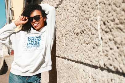 Mockup of a Trendy Woman Posing with a Pullover Hoodie and Sunglasses