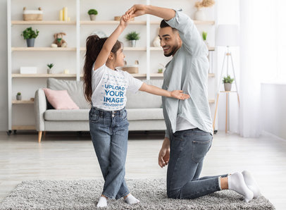 T-Shirt Mockup Featuring a Girl Dancing with her Dad in the Living Room