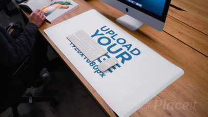 Video of a Desk Pad Lying Over a Wooden Table Featuring a Man Sitting in the Corner