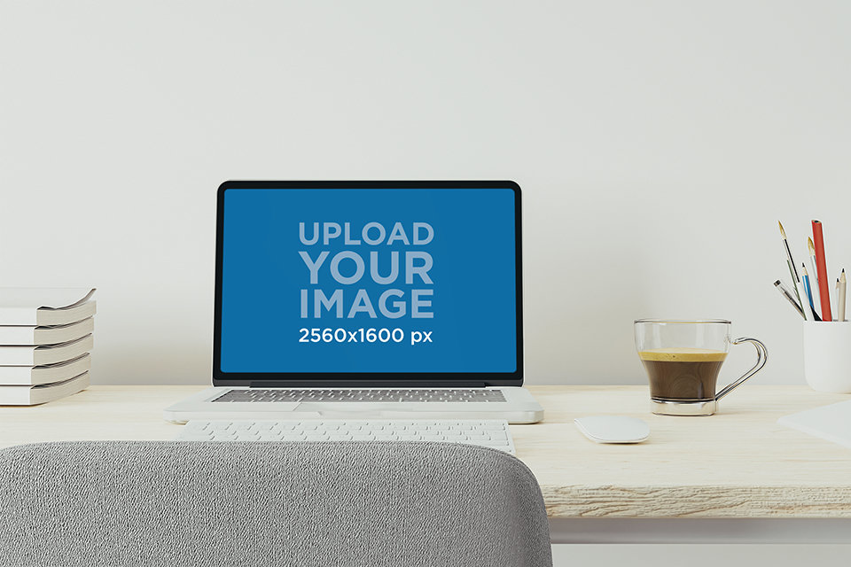 Mockup of a MacBook Pro Placed on a White Desk