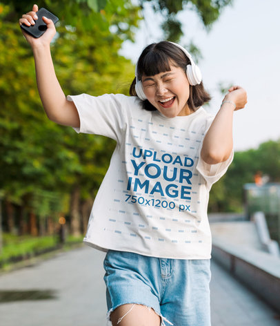 T-Shirt Mockup of a Happy Woman with Headphones Dancing to Music