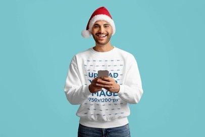Sweatshirt Mockup of a Happy Bearded Man With a Santa Hat Using a Phone