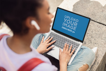 MacBook Mockup Featuring a Young Female Student Sitting on the Ground