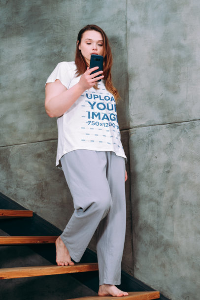 V-Neck T-Shirt Mockup of a Woman Checking a Smartphone and Going Down the Stairs