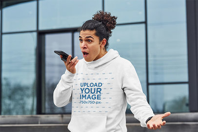 Pullover Hoodie Mockup of a Man Talking on His Smartphone with a Surprise Expression