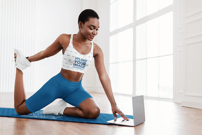 Sublimated Sports Bra Mockup Featuring a Woman Stretching Her Leg on a Yoga Mat