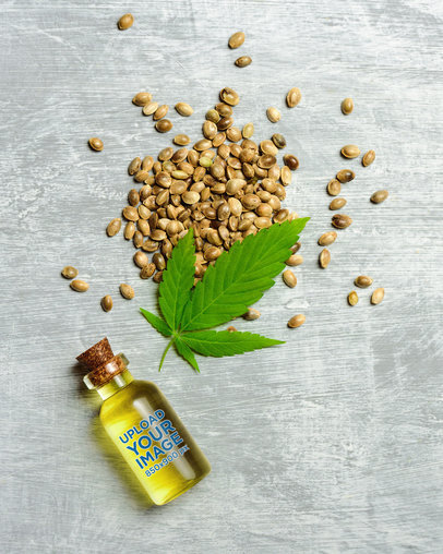 Glass Bottle Mockup Featuring Cannabis Seeds and a Leaf 