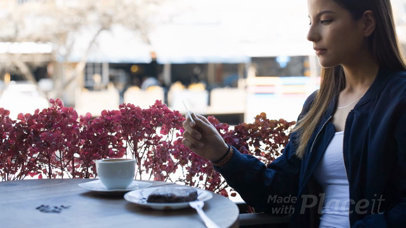 Gorgeous Woman Looking at a Business Card Video While at a Cafe