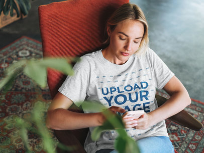 T-Shirt Mockup Featuring a Woman Distracted Checking Her Phone m13682-r-el2