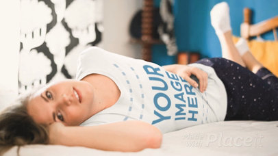 Young Woman Lying Down on a Bed Moving Her Leg Wearing a Round Neck Tee Cinemagraph