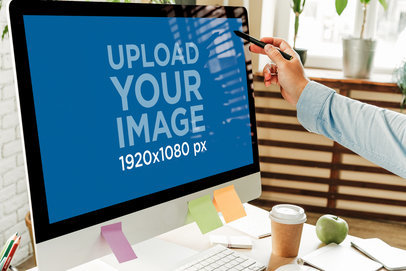 Mockup of a Man Ponting at an iMac in an Office