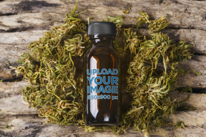 Mockup of a Glass Bottle on a Handful of Hemp