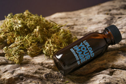 Mockup of a Pill Bottle Next to a Handful of Cannabis on a Log