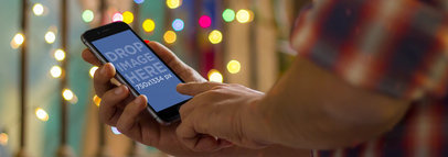 Wide Mockup of a Man Using an iPhone 6 with Festive Decor