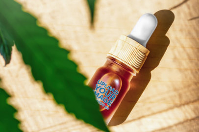 Mockup of a Dropper Bottle Featuring a Blurry Cannabis Plant