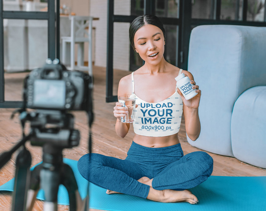 Crop Top Mockup Featuring a Woman Holding a Pill Bottle While Vlogging