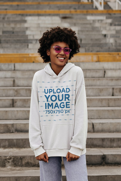 Hoodie Mockup Featuring a Cheerful Woman Posing in the Street