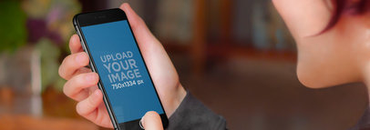 Mockup of a Woman Looking at an iPhone 6 in Portrait Position