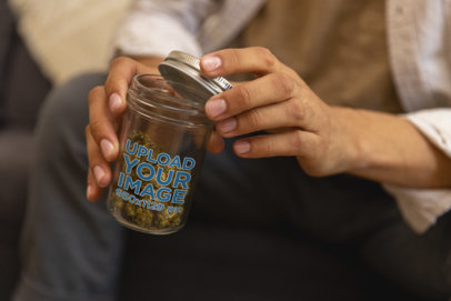 Mockup of a Man Holding a Mason Jar with Cannabis Buds