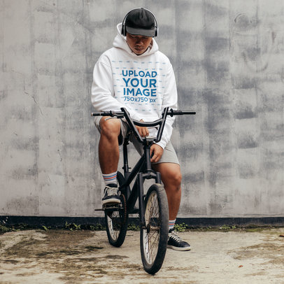 Hoodie Mockup Featuring a Serious Man Sitting on a Bike