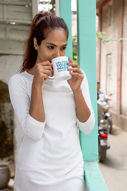 Mockup of a Woman Drinking from a Mug at a Balcony