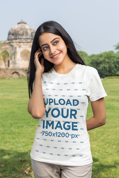 T-Shirt Mockup of a Young Woman Posing in Front of an Indian Temple