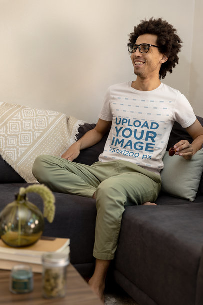 Cannabis-Themed T-Shirt Mockup of a Happy Man Laughing on a Couch M25451