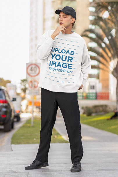 Oversized Sweatshirt Mockup Featuring a Man Posing on a Sidewalk