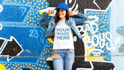 Young Trendy Woman Wearing a Hat and  a Tshirt Stop Motion Near a Graffiti Wall