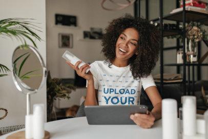 T-Shirt Mockup Featuring a Happy Woman Holding a Skincare Product