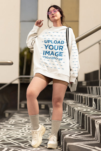 Mockup of a Young Woman Wearing an Oversized Sweatshirt in a Stairway