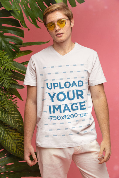 Mockup of a Cool Man with a V-Neck Tee Posing By Some Palm Leaves