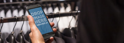 Mockup of an HTC One 8m in Portrait Position in a Suit Shop