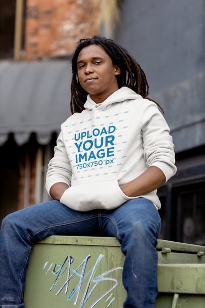 Mockup Featuring a Man with a Hoodie Sitting on a Dumpster