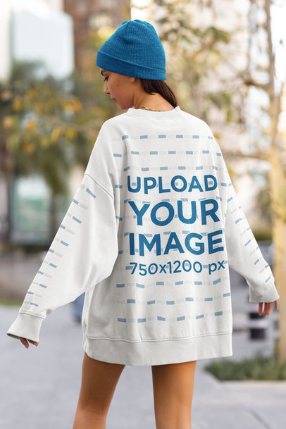 Back View Mockup of a Woman Wearing an Oversized Sweatshirt with Customizable Sleeves on the Street
