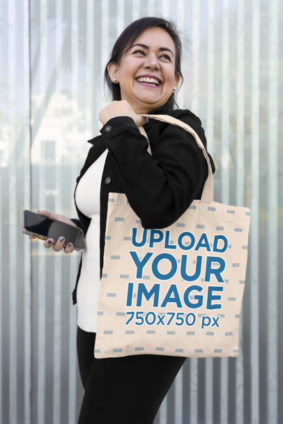 Mockup of a Smiling Woman Carrying a Tote Bag over Her Shoulder