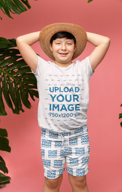 Mockup of a Young Boy Posing with a Tee and Swimming Trunks in a Tropical-Themed Set