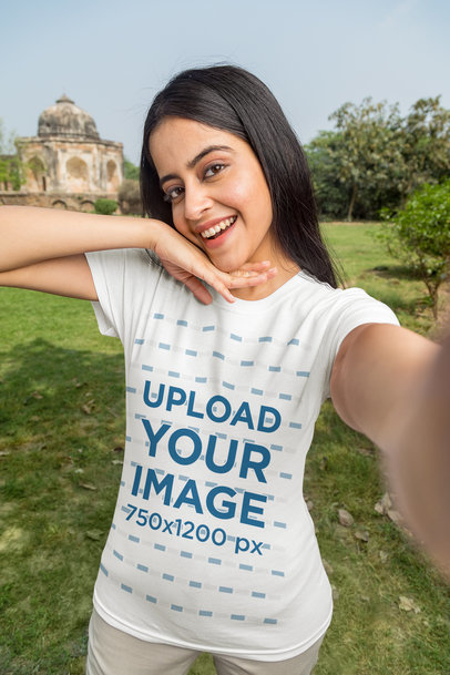 T-Shirt Mockup of a Happy Woman Taking a Selfie In a Garden