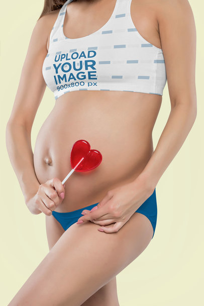 Sports Bra Mockup of a Pregnant Woman Holding a Lollipop in a Studio m15723-r-el2