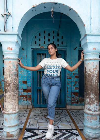 Mockup of a Woman Wearing a T-Shirt and Posing in Front of an Old Building