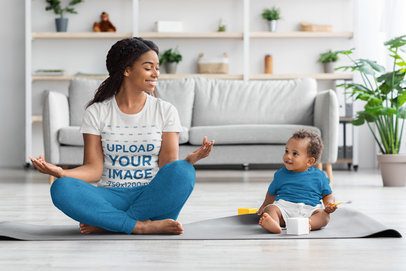 Mockup of a Woman Wearing a T-shirt and Meditating With her Baby at Home