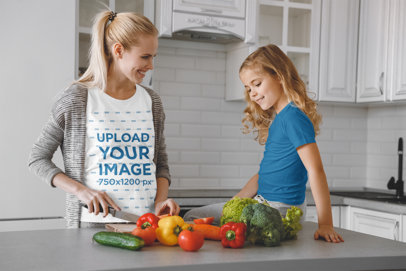 T-Shirt Mockup Featuring a Pregnant Woman Cooking With Her Daughter