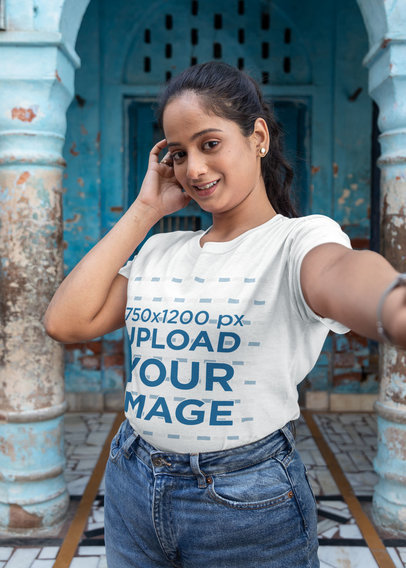 T-Shirt Mockup Featuring a Woman Taking a Selfie in Front of an Old Building