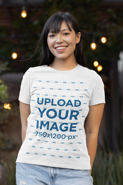 Mockup of a Happy Woman Wearing a Bella Canvas T-Shirt With Lights in the Background